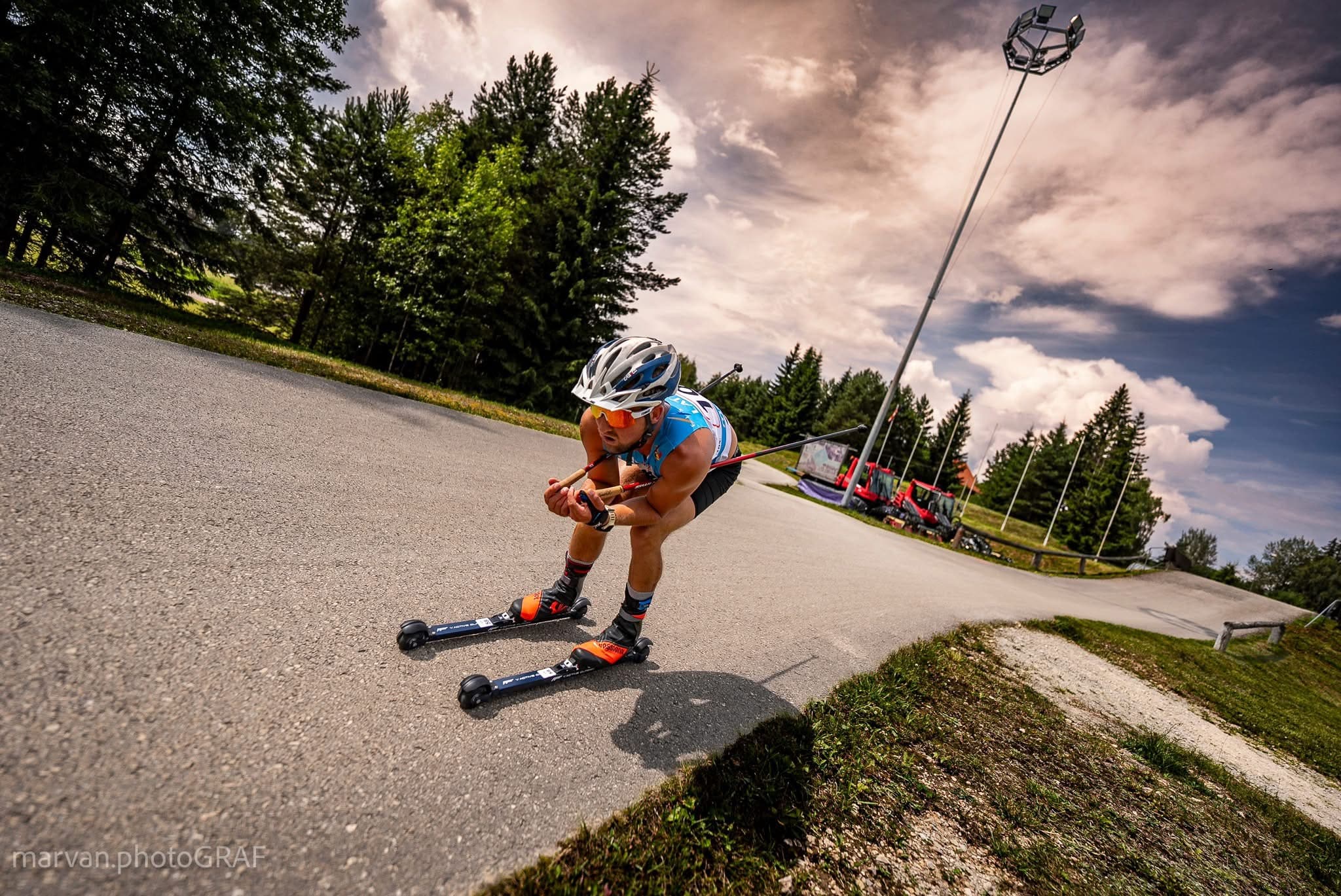Athlete roller skiing on a pathway.